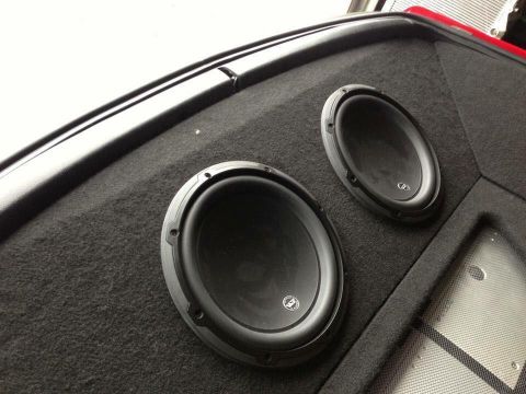 1994 Toyota Supra - A close-up view of two aftermarket subwoofers mounted in a custom enclosure within a vehicle.