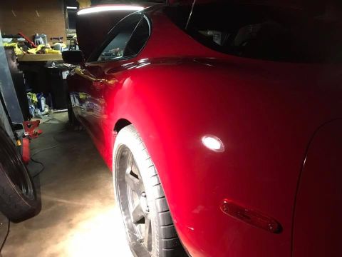 1994 Toyota Supra - Rear view of a red 1994 Toyota Supra with hood open in a garage setting.
