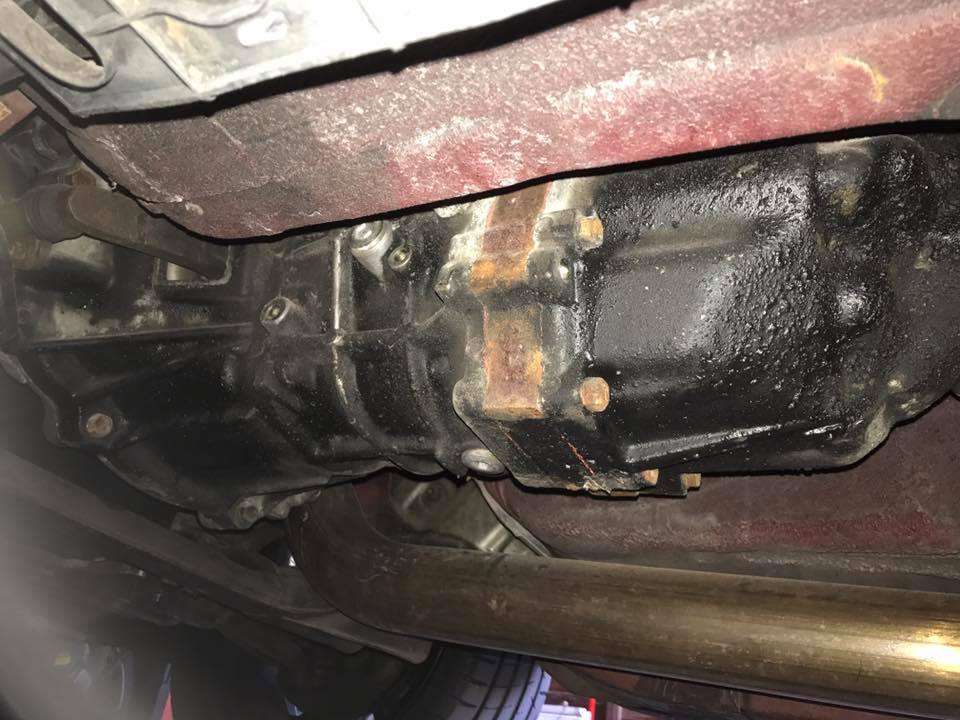 Underside view of a vehicle's transmission housing and exhaust pipe