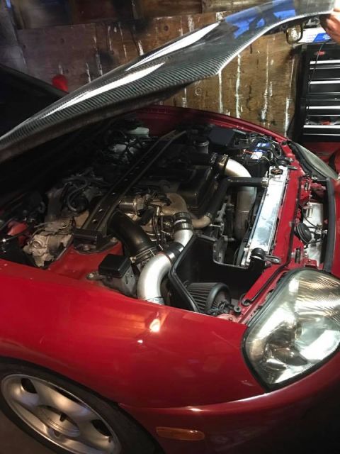 1994 Toyota Supra - Engine bay of a 1994 Toyota Supra, aftermarket turbo modifications and a carbon fiber hood.