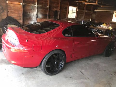 1994 Toyota Supra - A red 1994 Toyota Supra coupe is parked in a garage.