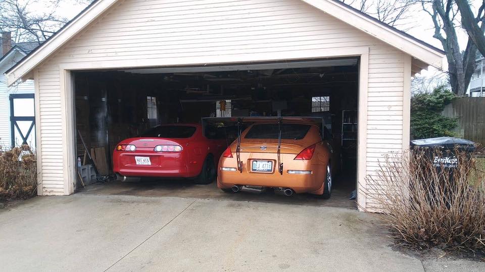 Red Toyota Supra and orange Nissan 350Z parked in a garage