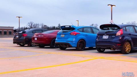 1994 Toyota Supra - A line of four sports cars, including a 1994 Toyota Supra, are parked in an outdoor lot.