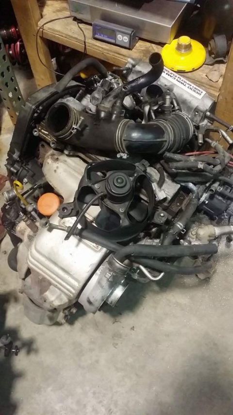 1988 Toyota Celica - Engine assembly with various hoses and a fan is shown on a concrete floor.