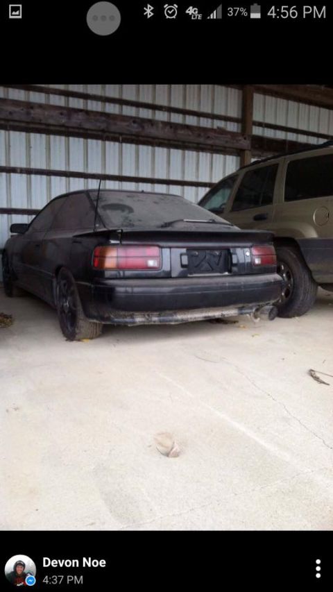 1988 Toyota Celica - This black 1988 Toyota Celica coupe is seen from the rear, parked in a garage next to another vehicle.