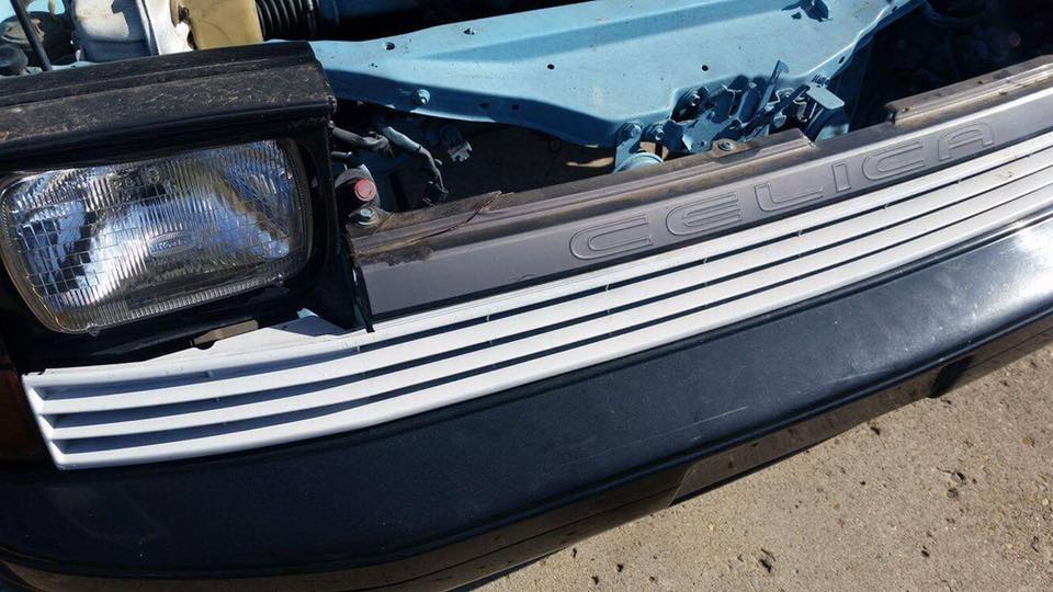 1988 Toyota Celica grille with horizontal slats and embossed name, next to a headlight