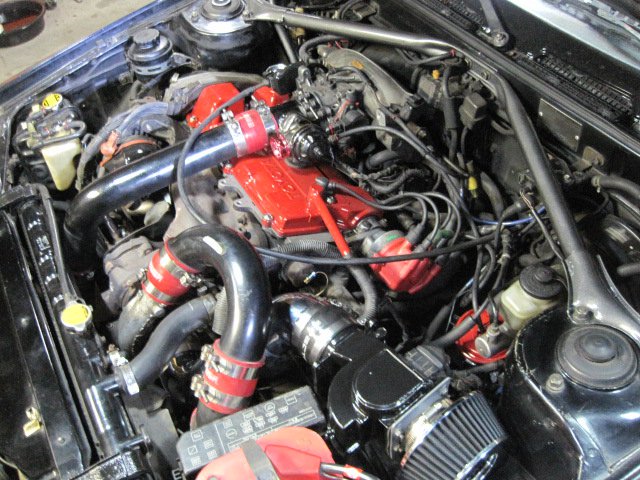 1988 Toyota Celica engine bay with turbocharger and red valve cover