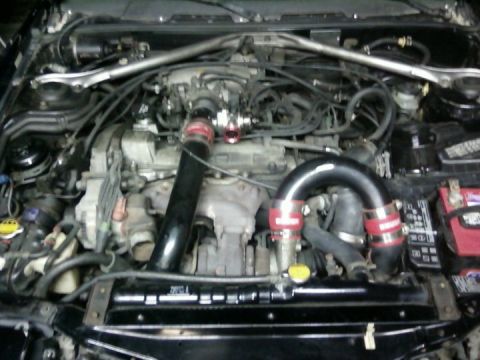 1988 Toyota Celica - The engine bay of a 1988 Toyota Celica shows a modified intake system and a silver strut tower brace.