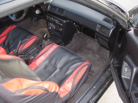1988 Toyota Celica - The interior of the car shows aftermarket seat covers and a manual transmission shifter.