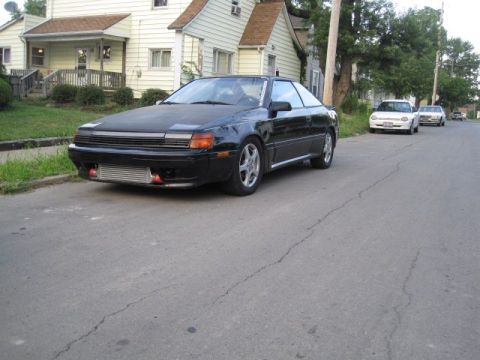 1988 Toyota Celica - A black coupe with an exposed intercooler sits on a residential street.