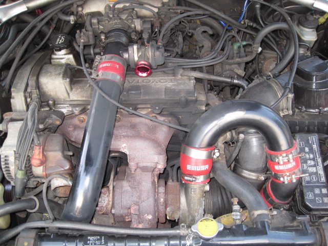 engine bay with turbocharger and custom piping. Toyota branding visible on engine cover
