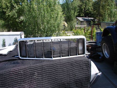 1973 Ford Ranchero - A close-up view of a vehicle's front grille, resting on a protective cover outdoors.