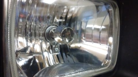 1985 Ford Bronco - This is a close-up view of a vehicle's headlight assembly, showing the reflector and bulb socket.