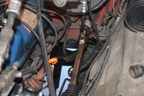 1978 Ford Bronco - Close-up view of the steering column and engine bay of a vehicle, with various mechanical parts visible.