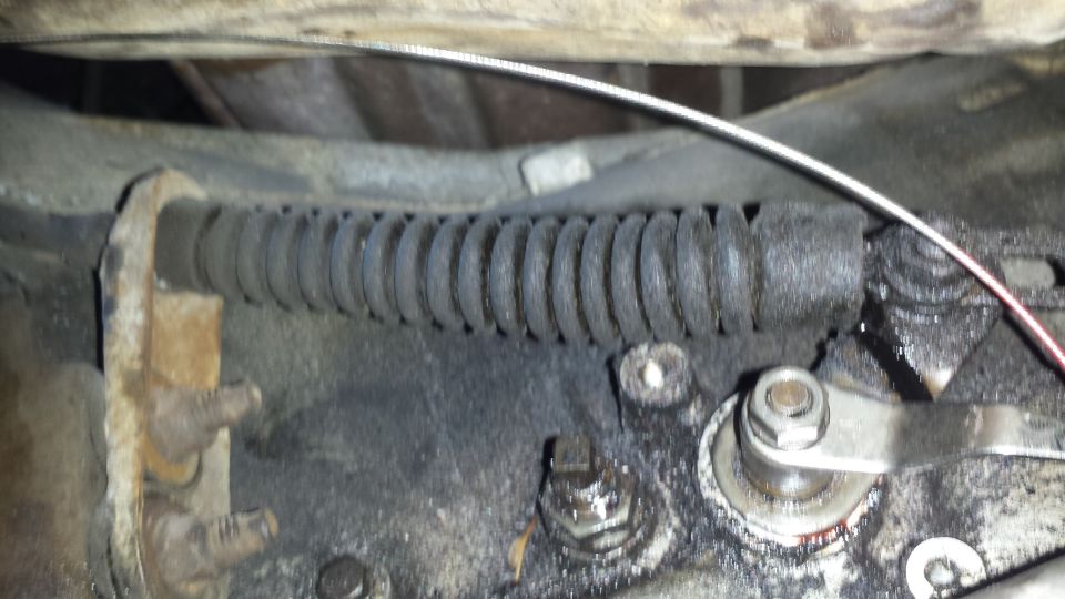 Close-up of a vehicle's parking brake cable and linkage