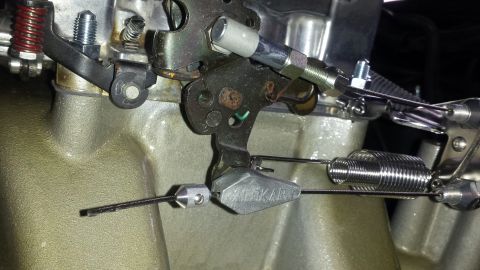 1976 Ford Ranchero - This close-up shows the intricate mechanical linkage of a carburetor, including springs and cables.