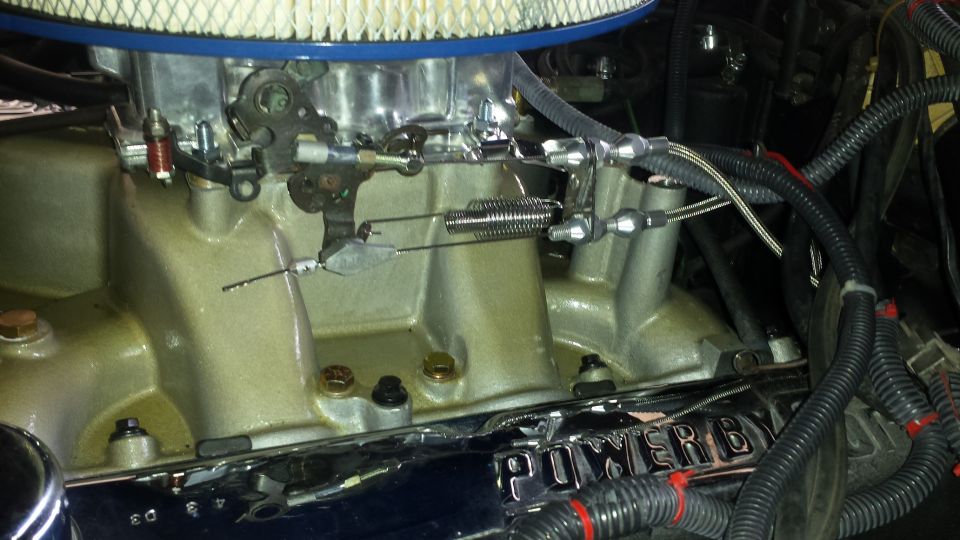 Engine intake manifold with carburetor, throttle linkage, and air filter. Chrome trim reads 'POWER BY'