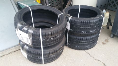 2006 Mitsubishi Evolution - A set of four tires are stacked and secured with white straps, ready for transport or storage.
