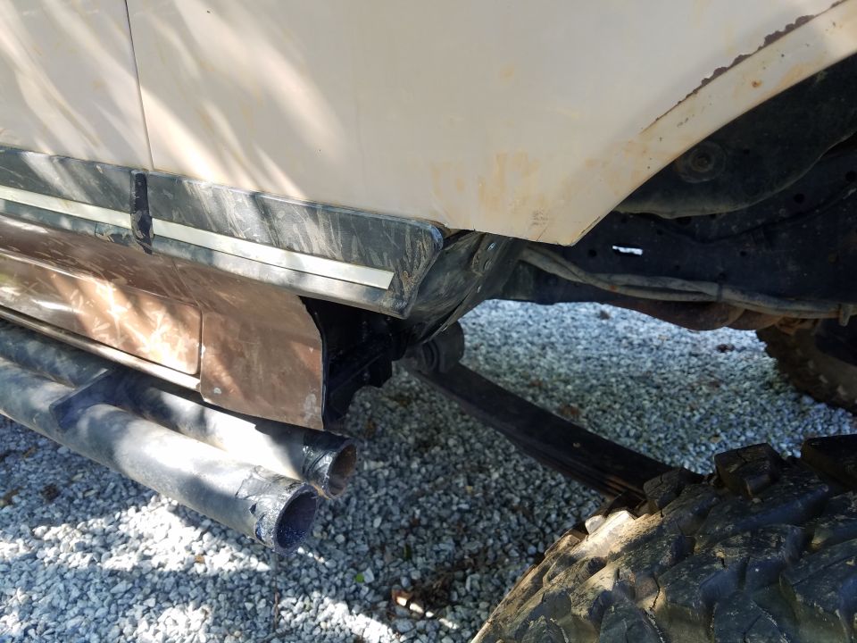 1988 Ford Bronco side view showing lower body trim, dual exhaust pipes, and suspension components