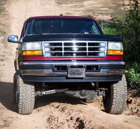 1995 Ford Bronco - This 1995 Ford Bronco is shown from the front, a red body with a black hood and grille.