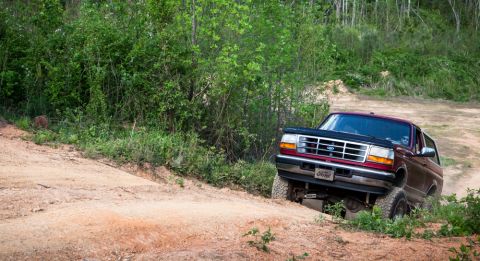 1995 Ford Bronco - 1995 Ford Bronco navigating an off-road trail.