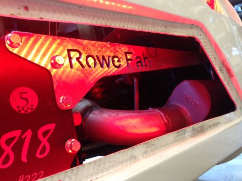 2015 Subaru Impreza - A close-up view of a custom exhaust system component, illuminated by red lights, with visible branding and numbering.