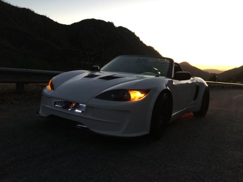 2015 Subaru Impreza - A white convertible sports car is parked on the side of a road as the sun sets behind the mountains.