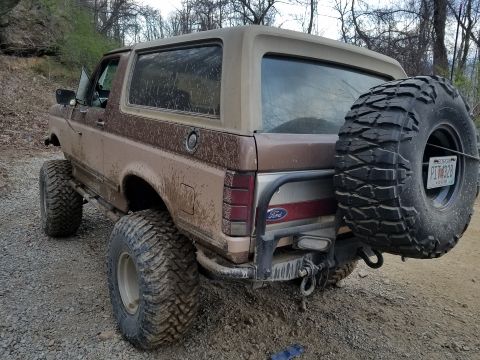 1988 Ford Bronco - This lifted Ford Bronco is covered in mud, suggesting it has been off-roading.