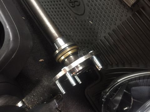 1982 Ford Bronco - Close-up of a vehicle's axle shaft and hub assembly resting on a floor mat.
