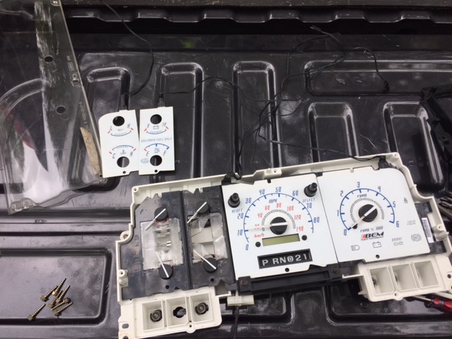 Disassembled 1996 Ford Bronco instrument cluster with gauges and digital display.