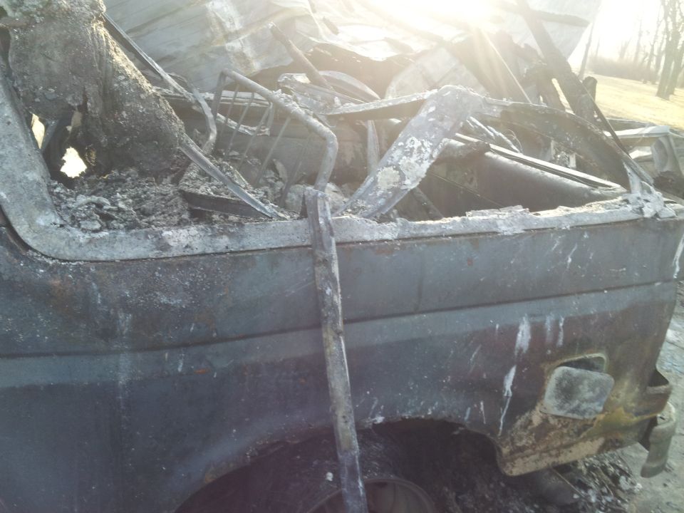 Interior of a burnt-out vehicle, showing melted dashboard and structural damage