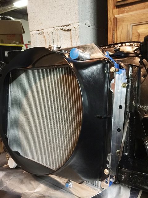 1978 Ford Bronco - A close-up view of the front of a vehicle's radiator assembly, featuring a black shroud and aluminum fins. The assembly is partially instal…