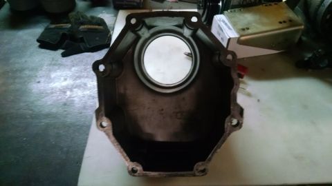 1985 Jeep CJ7 - A metal automotive part, likely a transmission bell housing, is shown from a top-down perspective. The part is octagonal with a circular op…