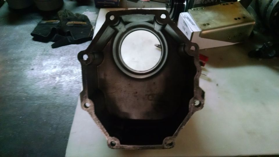 Metal transmission bell housing with circular opening and mounting holes.