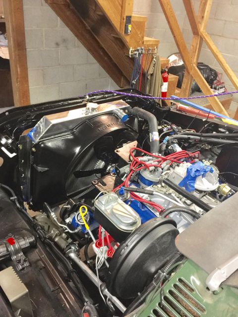 1978 Ford Bronco - The engine bay of a classic vehicle, likely a 1978 Ford Bronco, is shown with a new aluminum radiator and fan assembly installed. Visible c…