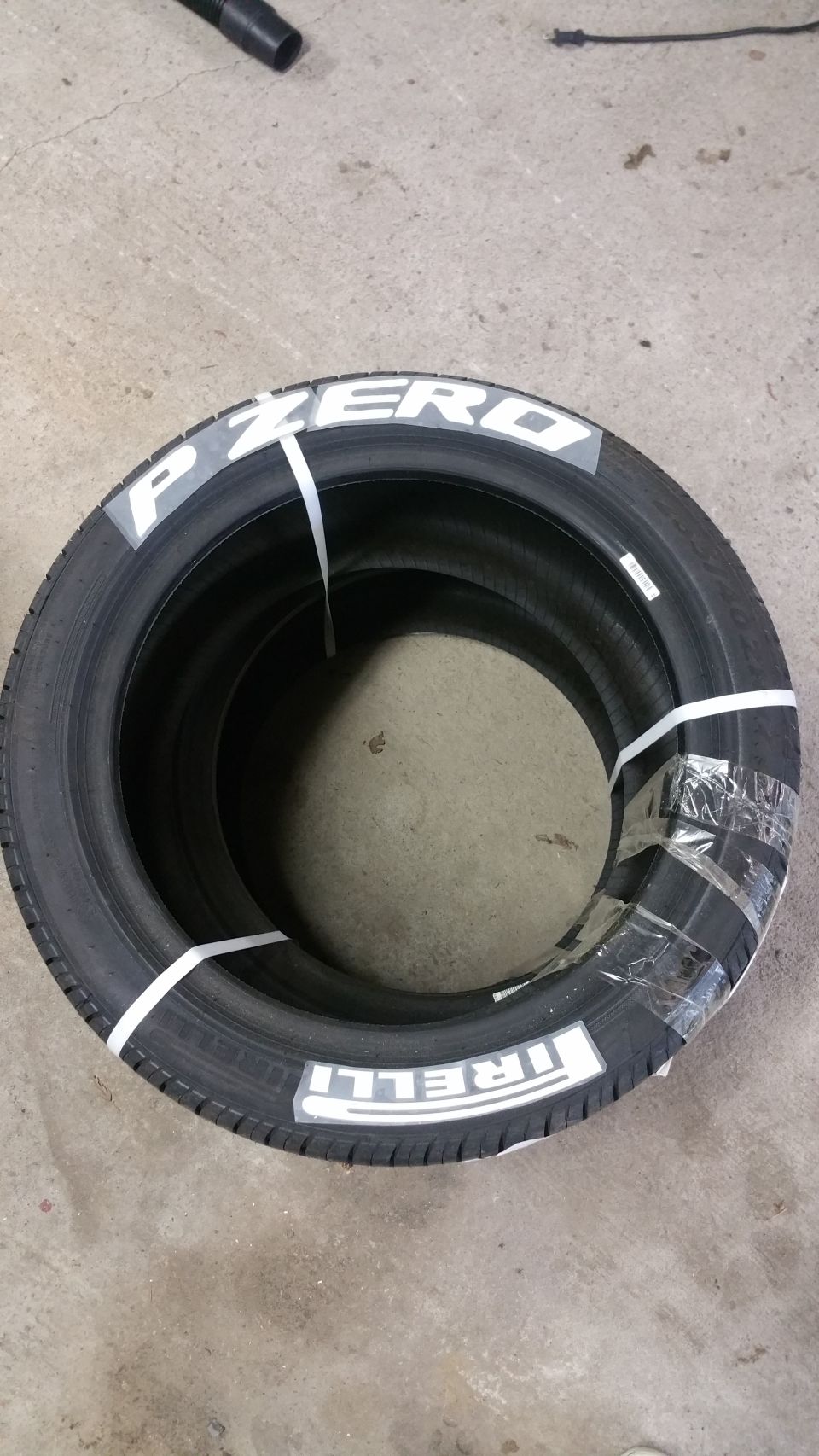 Two Pirelli P Zero tires stacked and strapped together, showing white lettering.