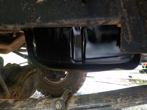 1988 Ford Bronco - The underside of a vehicle shows a black oil pan, exhaust pipe, differential, and leaf springs. The vehicle appears to be a truck or SUV.
