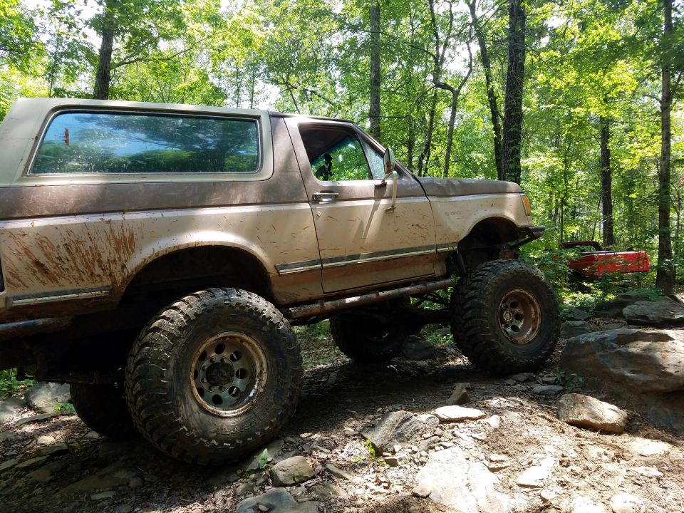 Tan and brown SUV with large tires on rocky terrain