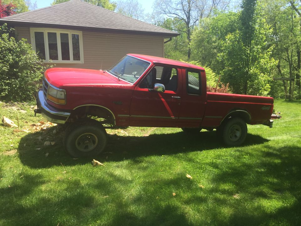 1996 Ford F-150 pickup truck parked on grass in front of a house