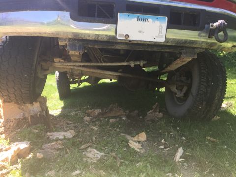1996 Ford F-150 - The rear suspension and undercarriage of a 1996 Ford F-150 are visible, with an Iowa license plate mounted on the bumper.