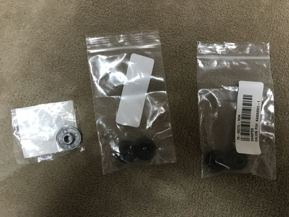 Three bags of small black rubber grommets and damper parts with part labels
