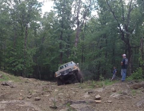 1988 Ford Bronco - Ford Bronco navigates a challenging rocky trail in a wooded area.
