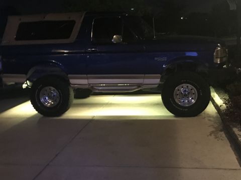 1996 Ford Bronco - This 1996 Ford Bronco is seen from the side, a blue body and a tan removable top.