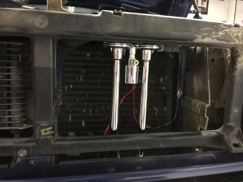 1996 Ford Bronco - Chrome air horns with red wiring are visible behind a vehicle's grille.