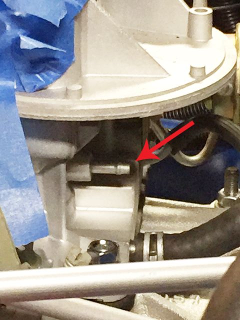 1978 Ford Bronco - This image shows a close-up view of a vehicle's carburetor assembly, with a red arrow highlighting a specific part.