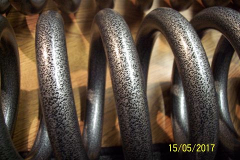 1995 Ford Bronco - Close-up view of speckled gray suspension coil springs, possibly aftermarket parts.