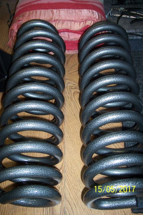 1995 Ford Bronco - Pair of aftermarket suspension coil springs shown on a wooden surface.