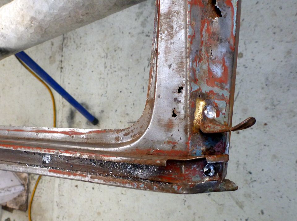 rusted car door frame section with latch mechanism visible
