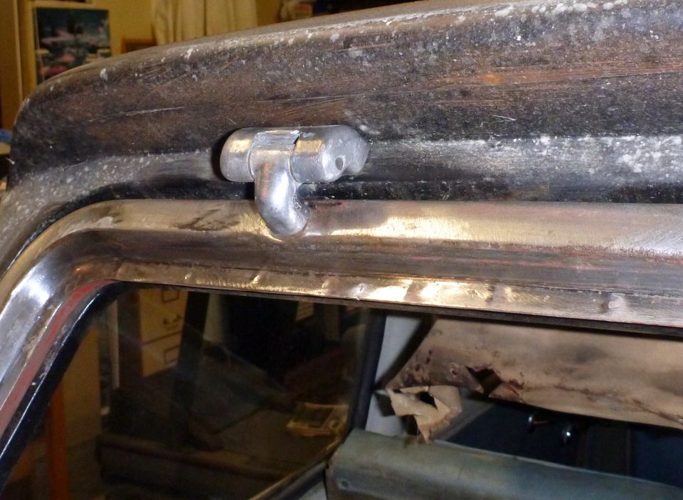 Close-up of a metal door latch mechanism on a car's window frame
