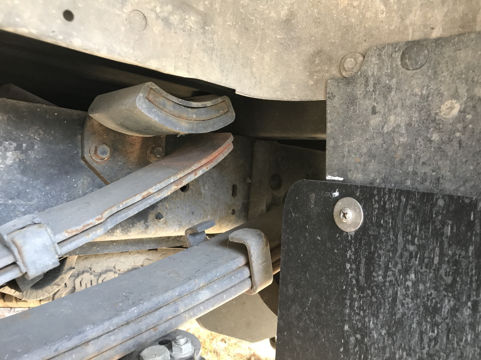 Close-up of a vehicle's leaf spring, U-bolt, and rubber bump stop